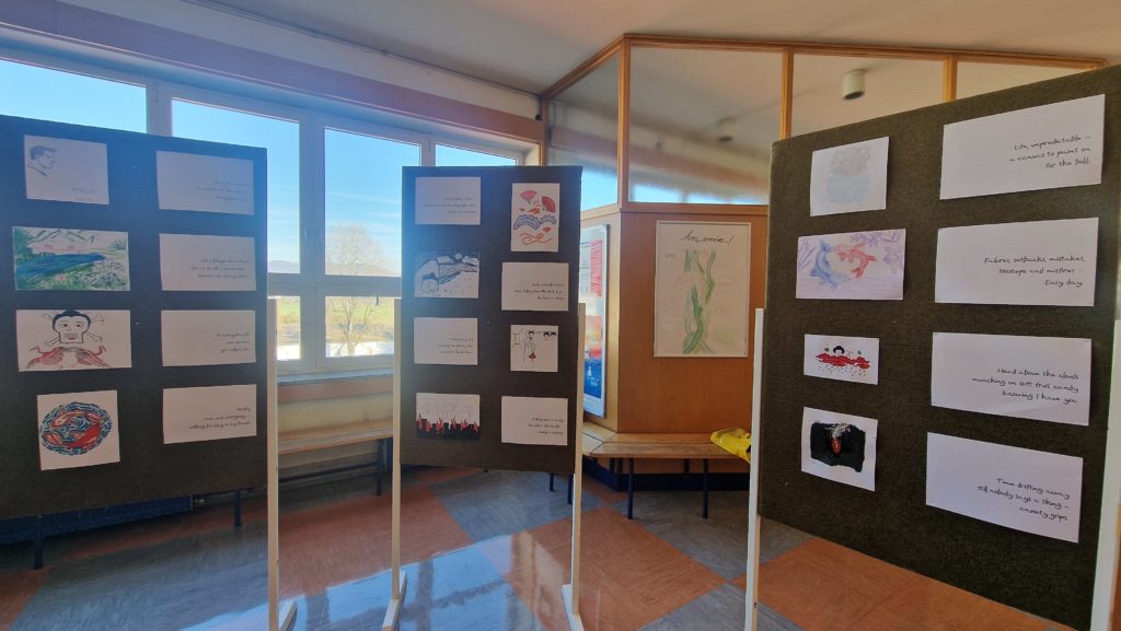 Trije razstavni panoji z risbami in pesmimi, postavljeni v šolskem hodniku ob velikih oknih.