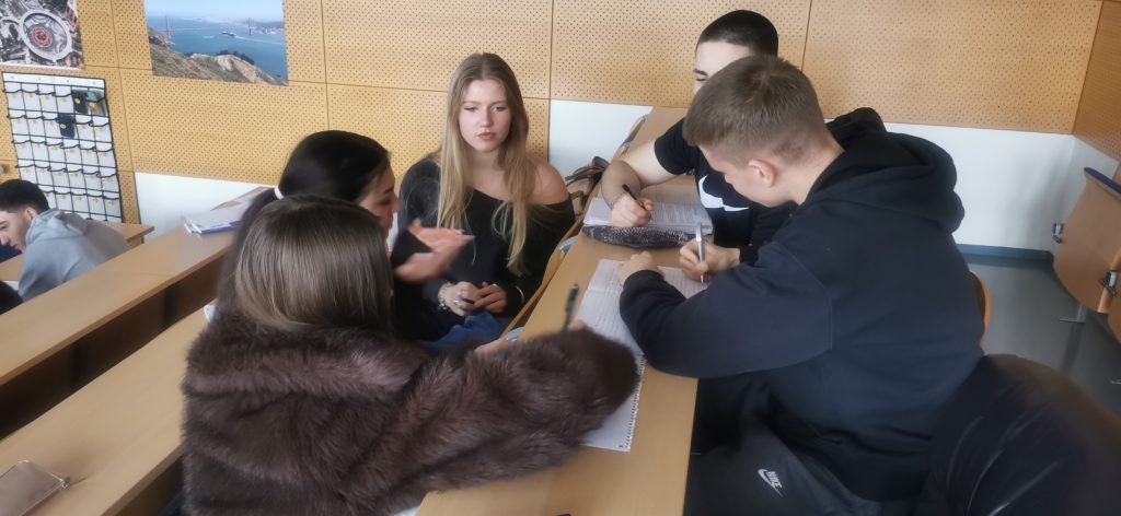 Dijakinje in dijaki 2.a in 2.c, ki v skupinah analizirajo svoje ugotovitve, delajo statistiko svojih nakupovalnih navad in o ugotovitvah poročajo ostalim sošolcem.