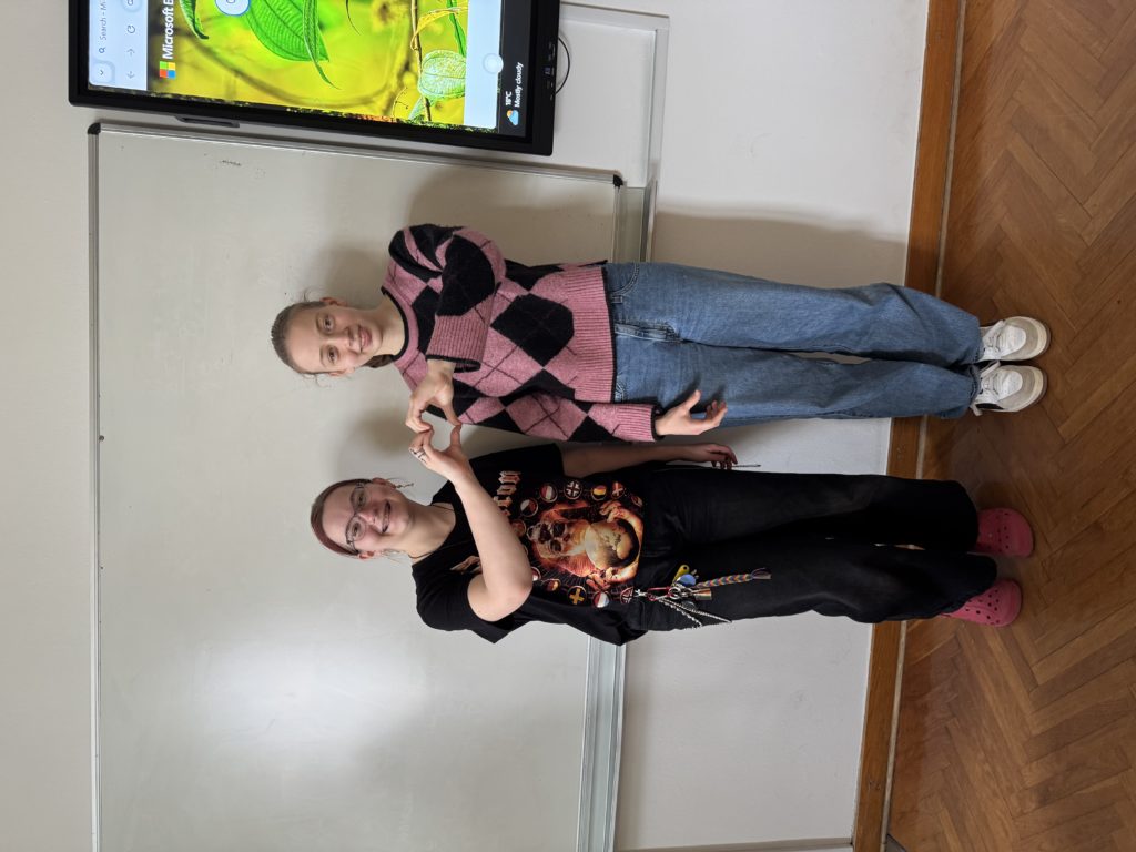 Dijakinji Anteja Puš, 4. A in Mia Levič, 2. E, nasmejano stojita pred tablo.